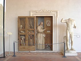scheinbar geöffnete Tür, die Einblick gibt in eine Mönchszelle; mit Fercoldo, der auf eine Abbildung seines Sohnes, den späteren Papst Clemens IV. zeigt